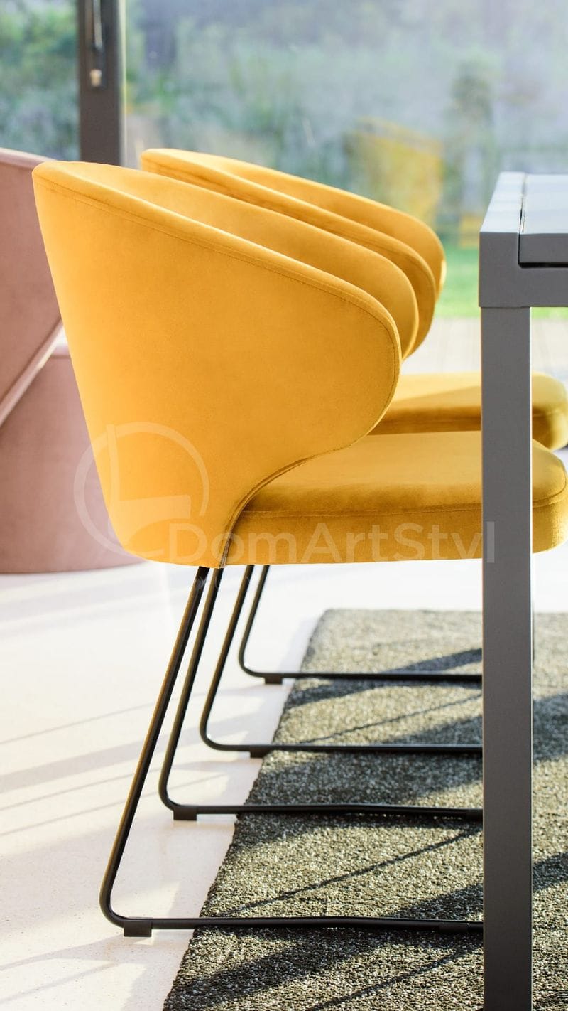 Żółte krzesło welurowe na czarnych płozach